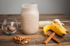 a glass jar filled with food sitting on top of a wooden table next to bananas and cinnamon