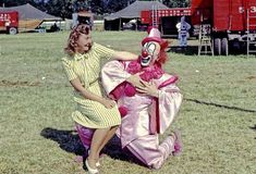 two people dressed as clowns pose for a photo