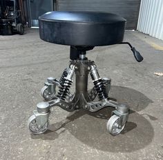 a black chair with four wheels on it's back and one wheel attached to the seat