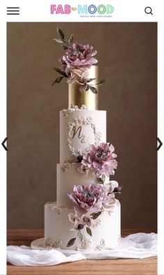 a three tiered wedding cake with pink flowers on top and gold trimmings