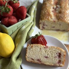 two slices of strawberry lemon pound cake on plates next to a bowl of strawberries