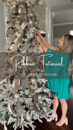 a woman is decorating a christmas tree with silver and gold ornaments on it's branches