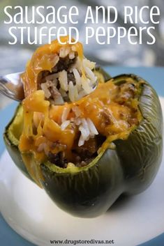 sausage and rice stuffed peppers on a white plate with a spoon in the top half