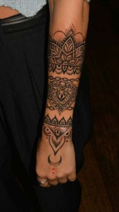 a woman's arm with tattoos on it and her hand holding the wrist tattoo