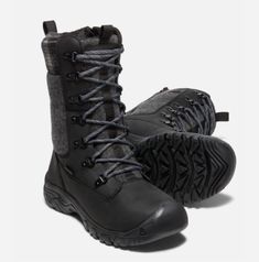 a pair of black boots with grey laces on the outstep and side zipper