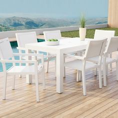 a white table and chairs sitting on top of a wooden floor next to a pool