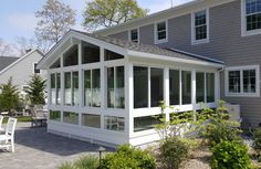 a large gray house with white trim and windows