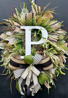 a monogrammed wreath with the letter p hanging on a black door hanger