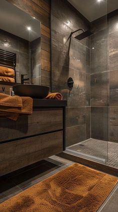 a bathroom with a walk in shower next to a sink and toilet covered in brown towels