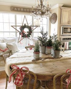 a dining room table with potted plants on it and a star hanging from the ceiling