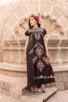 This Beautiful Dress boasts a Traditional Mexican floral design combined with a modern style dress.  The colorful flowers combined with the maxi length make it unique and elegant.  It's made out of fine Mexican cotton, is completely embroidered by hand and has some knit details. This dress is handmade and hand embroidered by Mexican Artisans in Puebla, Mexico. More dresses available here: https://www.etsy.com/es/shop/SoleiEthnic?ref=seller-platform-mcnav&section_id=25367133 Traditional Black Dress With Floral Print, Traditional Black Floral Print Dress, Traditional Floor-length Maxi Dress With Floral Embroidery, Multicolor Embroidered Floor-length Dress, Traditional Short Sleeve Maxi Dress With Floral Print, Traditional Floral Print Maxi Dress With Short Sleeves, Traditional Maxi Length Dress With Floral Embroidery, Traditional Short Sleeve Floral Maxi Dress, Traditional Maxi Dress With Embroidered Hem