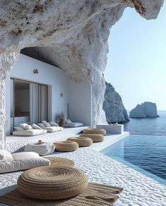 an outdoor pool area with large rocks and pillows on the floor, along with water