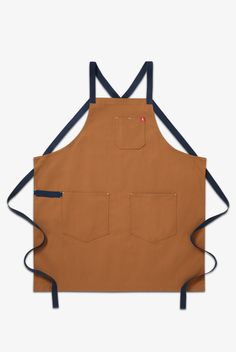 The All Day Crossback Apron draws inspiration from our favorite chefs. Our signature crossback straps enable carefree style and distribute weight across your shoulders and back for all day wearability. Big pockets and a towel loop add to our classic functionality. Our beautiful, lasting materials make this apron an instant icon constructed to last a lifetime. • Criss cross straps take pressure off your neck • Lotsa pockets and a utility loop for all your gear • 33" x 30" body, 72" straps 100% Co Crossback Apron, Brown Apron, Waitress Apron, Shop Apron, Michelin Star Chef, Chef Uniform, Best Boyfriend Gifts, Work Aprons, Aprons For Men