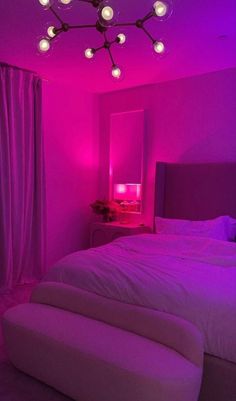 a bedroom with purple lighting and a bed in the middle is lit up by pink lights