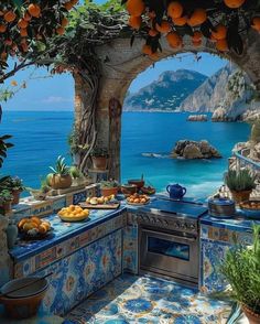 an outdoor kitchen with blue tile and oranges on the counter top, overlooking the ocean