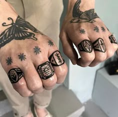 two hands with tattoos on them holding each other