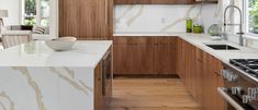 a kitchen with marble counter tops and wooden cabinets