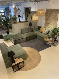 a living room filled with lots of green couches and pillows on top of a rug