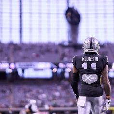 a football player standing on top of a field wearing a black and white uniform with the number 4 on it