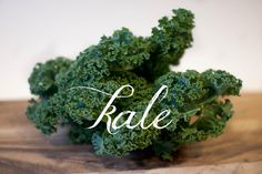 kale on a wooden cutting board with the word sale written in cursive font