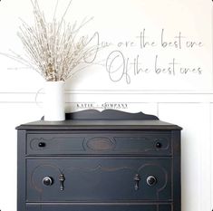 a black dresser with a white vase on top