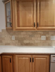 a kitchen with wooden cabinets and white counter tops