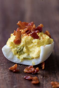 deviled eggs with bacon on a wooden table