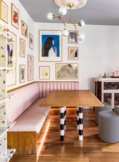 a dining room with pink booths and pictures on the wall