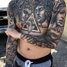 a man with many tattoos on his chest and arms is standing in front of a car