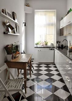 a kitchen with black and white checkered flooring next to a stove top oven