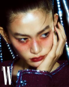 a woman with blue eyes and dark makeup is posing for the cover of w magazine