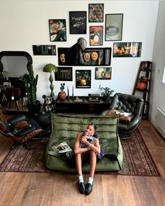 a woman sitting on top of a green couch