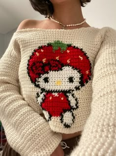 a close up of a person wearing a sweater with an image of a strawberry on it