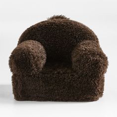 a brown fuzzy chair sitting on top of a white floor