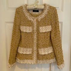 Meicai “Chanel Style” Tweed Jacket In Gold/Beige/White. This Beautiful Jacket Has Decorative Buttons In The Front And Four Faux Pockets. Fully Lined. Size Xs. Never Worn So In Perfect Condition And With Tags Still Attached. This Jacket Would Look Great With Either Distressed Jeans And A High Heel, Or Over A Dress As More Of An Evening Look. Smoke-Free And Pet Free Home. Cream Tweed Outerwear For Fall, Fall Cream Tweed Outerwear, Spring Beige Tweed Outerwear, Brown Tweed Outerwear For Spring, Spring Brown Tweed Outerwear, Cream Tweed Jacket For Spring, Spring Beige Tweed Blazer, Style Tweed Jacket, Chanel Style Jacket