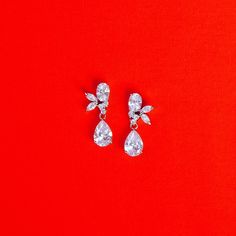 pair of diamond earrings on red background