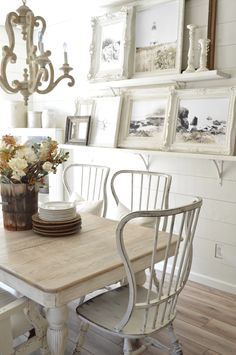 a dining room table and chairs with pictures on the wall above it, along with other decor