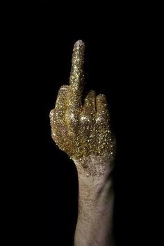 a hand with gold glitter on it making the middle finger to spell, rebelliousous to the end