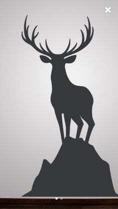 a deer standing on top of a hill next to a wall sticker that says,