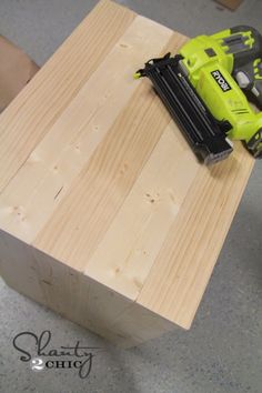 a cordless driller is sitting on top of a piece of wood that has been made into a table