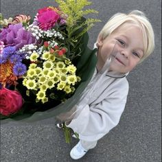 a young boy holding a bouquet of flowers