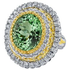 This beautifully handmade Italian ring features an exceptionally vibrant, 13.52 carat mint green tourmaline oval encircled by luxurious 18k gold and diamond halos! The tourmaline gemstone is a top-quality, crystalline beauty with exquisite mint green color and superior clarity, and has been faceted for maximum brilliance. The custom-designed ring is an elaborate work of art in itself, handmade in Italy of 18K white and yellow gold, in a Florentine-inspired design that showcases the highest level Green Multi-stone Topaz Ring For Formal Occasions, Formal Green Multi-stone Topaz Ring, Exquisite Green Multi-stone Diamond Ring, Luxury Green Gemstones With Halo Setting, Luxury Green Topaz Gemstone Ring, Luxury Green Tourmaline Emerald Ring, Luxury Green Sapphire Ring With Accent Stones, Luxury Green Sapphire Ring Gia Certified, Green Gia Certified Luxury Sapphire Ring