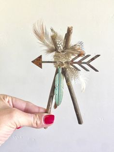 a hand holding an arrow with feathers on it