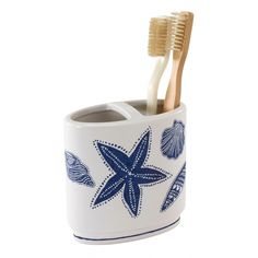 two toothbrushes in a cup with blue and white designs