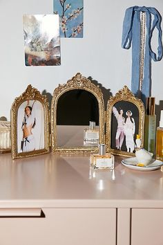 there are pictures on the counter in front of the mirror and other things to put on it