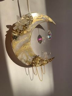 the moon is hanging on the wall next to some glass beads and other things in front of it