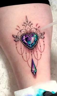 a woman's thigh with a heart and arrow tattoo on it