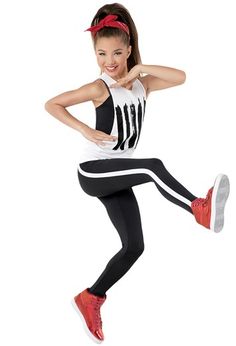 a girl in black and white running with her arms behind her back while wearing red shoes