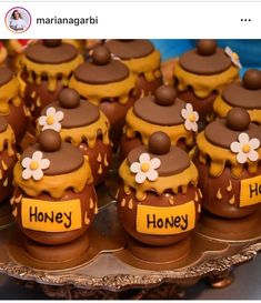 there are many cupcakes that have been decorated with honey and flowers on them