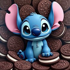 an adorable little blue elephant sitting on top of chocolate cookies with pink ears and eyes